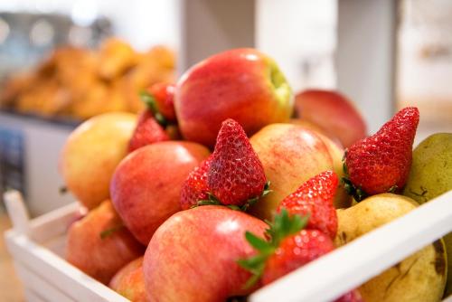 a white bowl filled with strawberries and other fruit at Hotel Isola Sacra Rome Airport in Fiumicino
