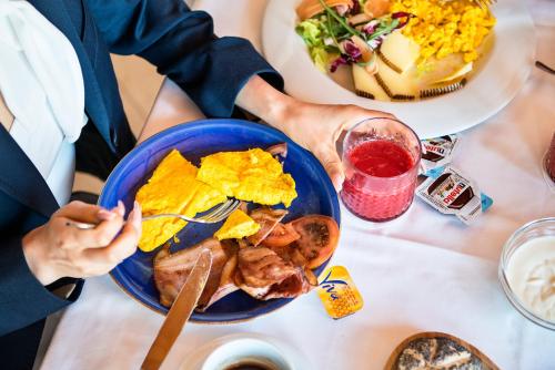 a person sitting at a table with a plate of food at Hotel Isola Sacra Rome Airport in Fiumicino