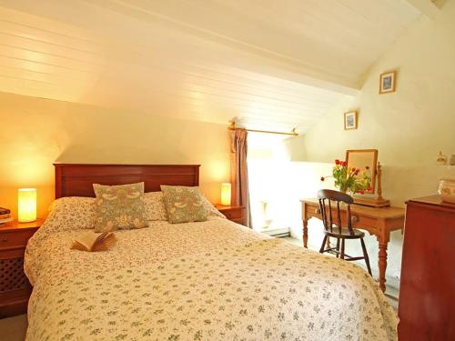 a bedroom with a bed and a desk and a desk at Buck Cottage in Pentraeth