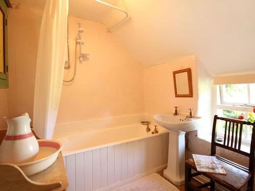 a bathroom with a tub and a sink at Buck Cottage in Pentraeth