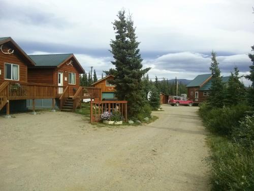 un camino de tierra frente a casas de madera en Alaskan Spruce Cabins, en Healy