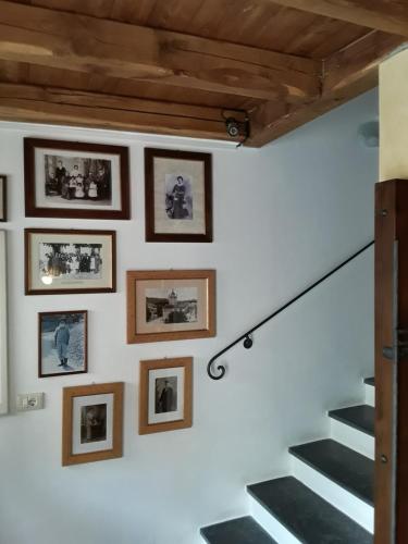 a wall with pictures and stairs in a house at Hotel Paese Corvara in Beverino