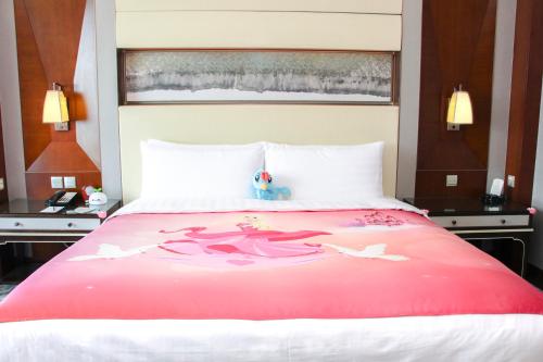 a bedroom with a large bed with a red blanket at Shangri-La Tangshan in Tangshan