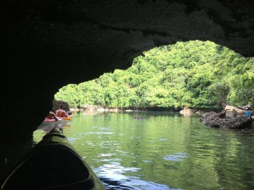 a view from the inside of a cave of a river with a person inside at Cat Ba Bay Cruises in Cat Ba