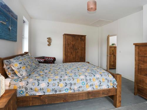 a bedroom with a bed with a blue and white comforter at Gwalia Stores in Beaumaris