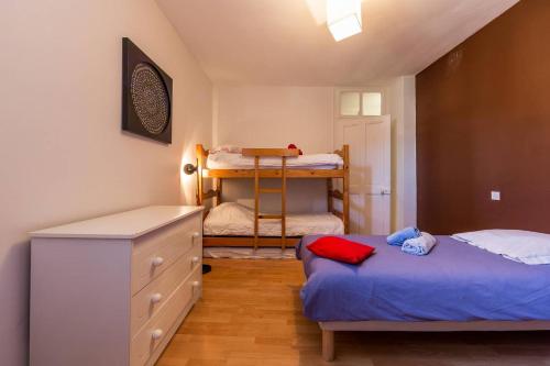 a bedroom with two beds and a dresser and bunk beds at Duplex au Bord du Lac in Duingt