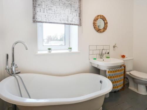 a bathroom with a tub and a sink at Gwalia Stores in Beaumaris