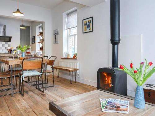 a living room with a fireplace and a dining room at Gwalia Stores in Beaumaris