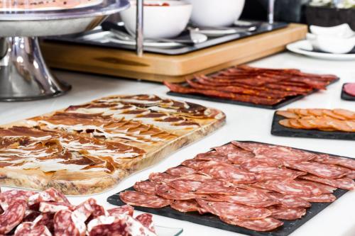 a table with meats and other foods on a counter at Hotel Spa Calagrande Cabo de Gata in Las Negras