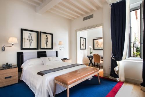 um quarto com uma grande cama branca e uma mesa em Palazzo Vecchietti - Residenza D'Epoca em Florença