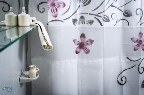 プエルト・マドリンにあるKosten al Marのバスルーム(紫色の花が咲くシャワーカーテン付)