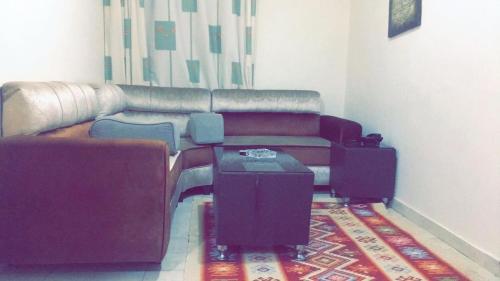 a living room with a couch and a table at Al Tawheed Hotel Apartments in Amman