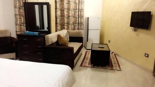 a living room with a bed and a couch and a tv at Al Tawheed Hotel Apartments in Amman