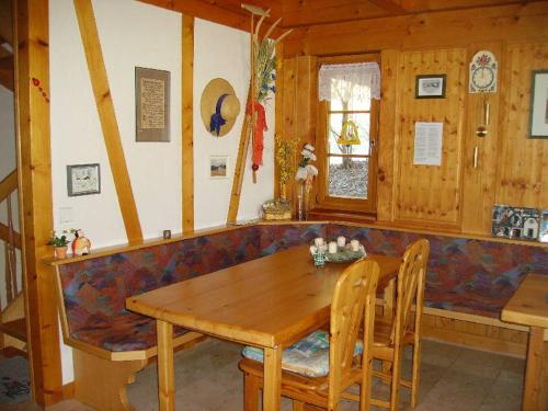 a dining room with a wooden table and a couch at Am Neuhausbauernhof in Königsfeld im Schwarzwald