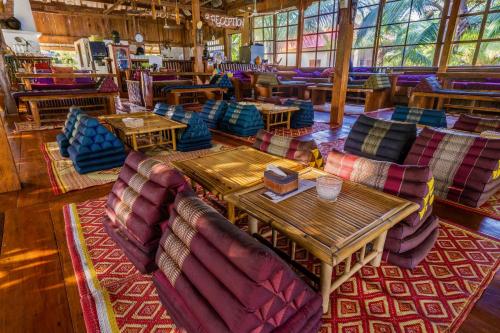 a restaurant with couches and tables in a room at Paradise Villas Koh Rong Sanloem in Koh Rong Sanloem