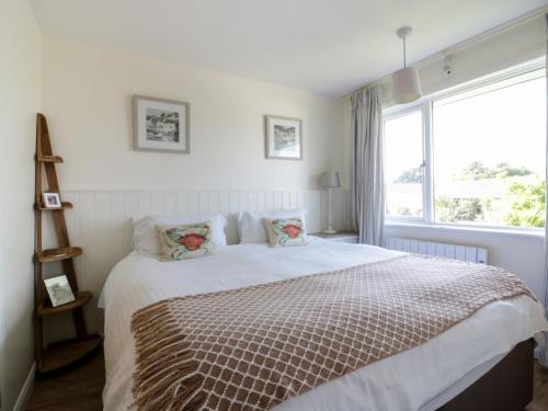a bedroom with a bed with a large window at Keelyn in Crantock