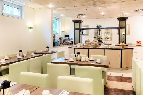 a restaurant with a table and chairs and a counter at ACHAT Hotel Frankenthal in der Pfalz in Frankenthal