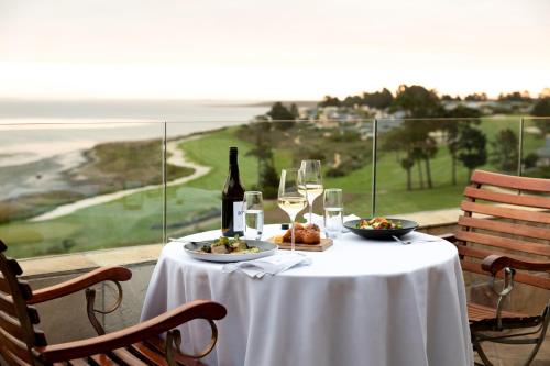 a table with a bottle of wine and a plate of food at Arabella Hotel, Golf and Spa in Kleinmond