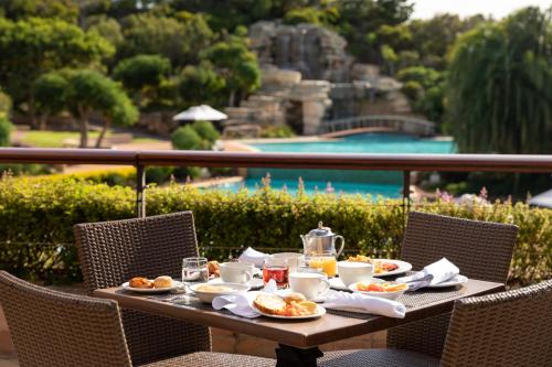 a table with food and drinks on top of a balcony at Arabella Hotel, Golf and Spa in Kleinmond