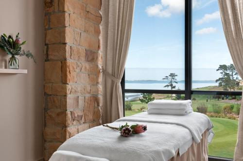 a bed in a room with a large window at Arabella Hotel, Golf and Spa in Kleinmond