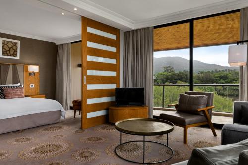 a hotel room with a bed and a large window at Arabella Hotel, Golf and Spa in Kleinmond