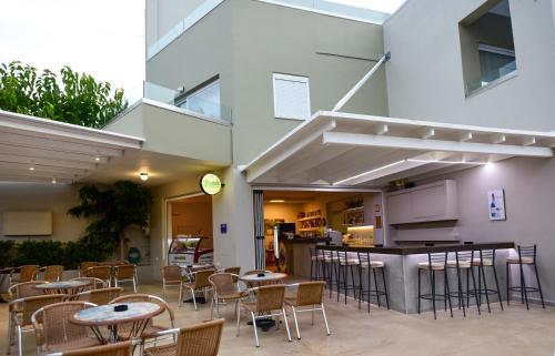 a restaurant with tables and chairs in front of a building at Blue Horizon Apartments in Balíon