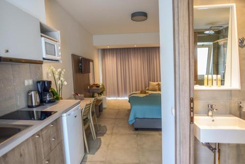 a kitchen with a sink and a room with a bed at Blue Horizon Apartments in Balíon