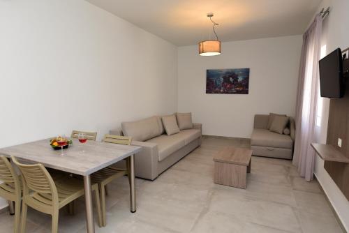 a living room with a table and a couch at Blue Horizon Apartments in Balíon