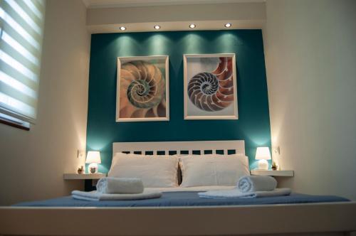 1 dormitorio con 1 cama con 3 cuadros en la pared en Little Nautilus en Tivat
