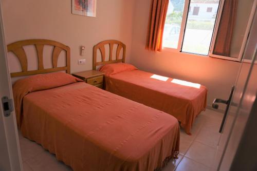 Habitación de hotel con 2 camas y ventana en ADELFAS, en Denia