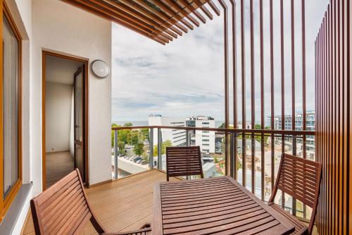 a balcony with two chairs and a view of a city at Olympic Park I, Sun & Snow in Kołobrzeg