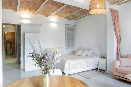 een slaapkamer met een bed en een tafel met bloemen erop bij Magic Apartment with Private Terrace in Barcelona