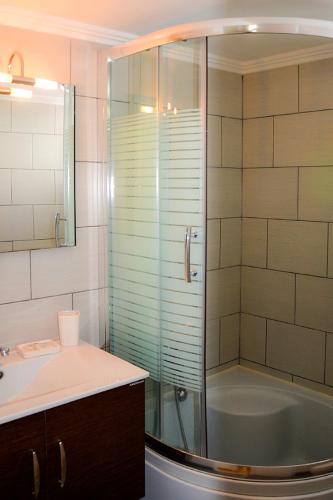 a bathroom with a shower and a sink and a tub at Golden View House in Pera Gyalos