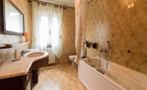 a bathroom with a sink and a tub and a toilet at Casa del Merlo in SantʼAndrea di Compito