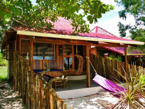 a small house with a pink roof and an umbrella at Paradise Villas Koh Rong Sanloem in Koh Rong Sanloem