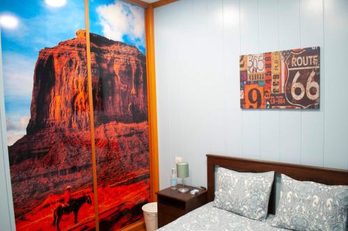 una camera da letto con un grande dipinto di una montagna di Room in My Vintage Home a Las Palmas de Gran Canaria