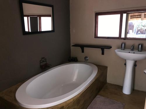 een badkamer met een groot bad en een wastafel bij NIANI tented Chalet in Hoedspruit