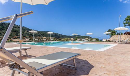 a pool with chairs and umbrellas in front of it at Villa Ginevra Resort Agrituristico in Ficarra