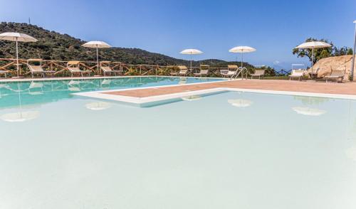 a swimming pool with chairs and umbrellas on top of it at Villa Ginevra Resort Agrituristico in Ficarra