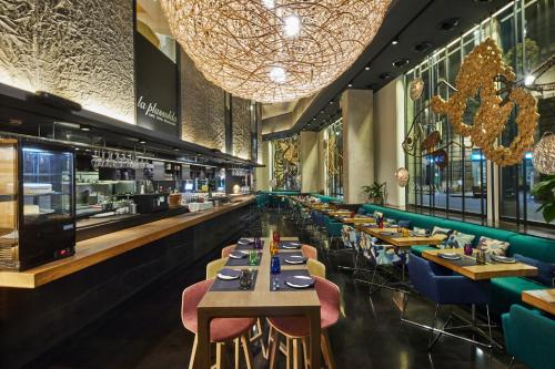 a restaurant with tables and chairs and a bar at Ohla Barcelona in Barcelona