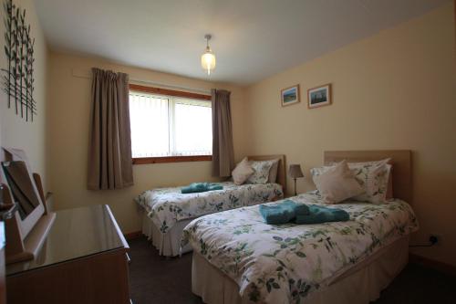 a hotel room with two beds and a window at An Airigh in Stornoway