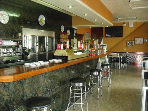 un bar en un restaurante con taburetes en El Faisan C&R Hotel en Arcos de la Frontera
