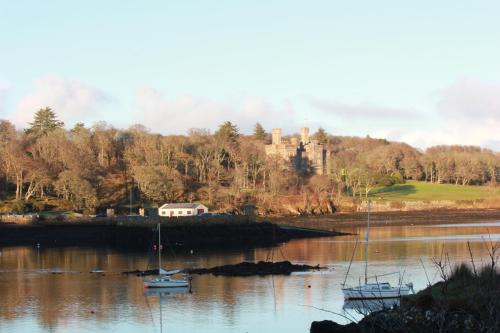 a castle and boats in a body of water at An Airigh in Stornoway