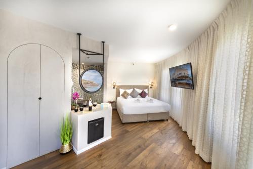 a bedroom with a bed and a tv in a room at Margosa Boutique Hotel Tel-Aviv Jaffa in Tel Aviv