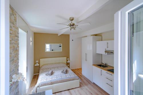 a small bedroom with a bed and a kitchen at Laglio Apartment Above George in Laglio