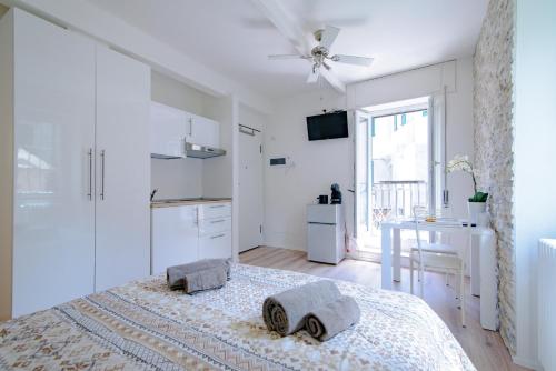 a white bedroom with a bed and a table at Laglio Apartment Above George in Laglio