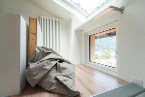 a room with a large window and a couch at Laglio Apartment Above George in Laglio