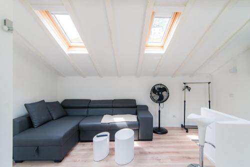 a living room with a blue couch and some windows at Laglio Apartment Above George in Laglio