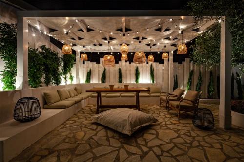 a living room with a couch and a table and chairs at Sun 'n Chill, Boutique Apartments & Beach Villa in Melíkia
