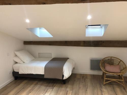 a bedroom with a bed and two skylights and a chair at Maison Simonenia in Saint-Jean-Pied-de-Port